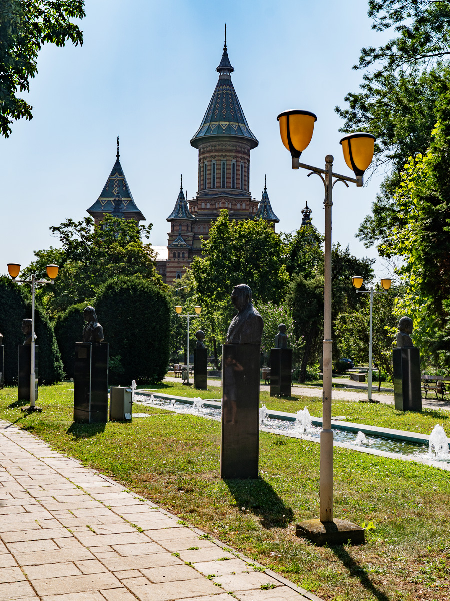 Büsten im Parcul Central mit der Metropolitan-Kathedrale von Timișoara im Hintergrund