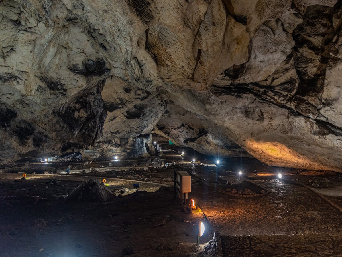 Beleuchtete Besucherwege unter der zerklüfteten Felsdecke der Magura-Höhle in Bulgarien.